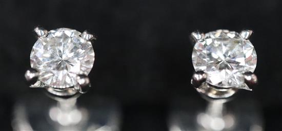 A pair of Cartier platinum set solitaire diamond ear studs, with Cartier box.